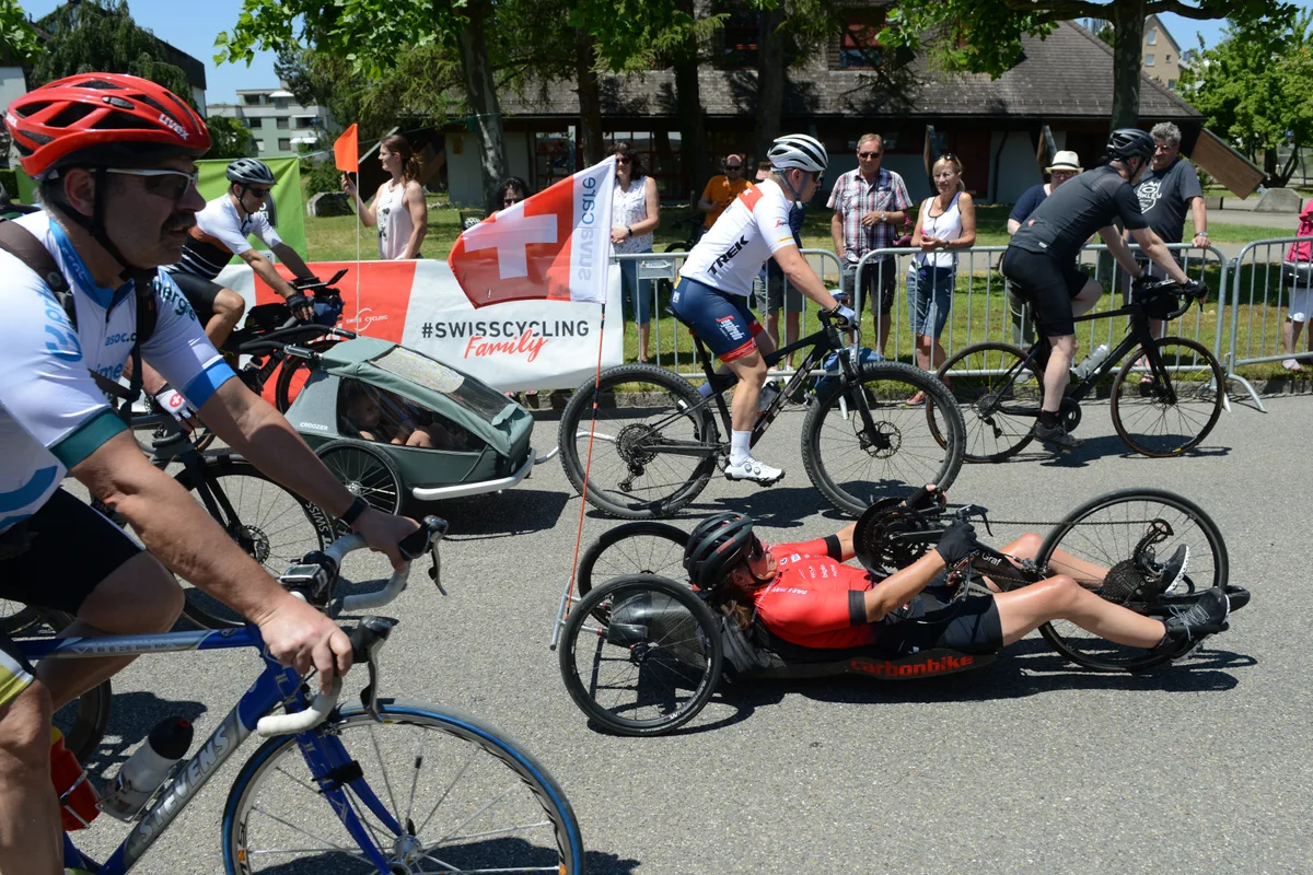 Auch zahlreiche Hobbyfahrer nahmen am «Memorial Ride» teil. Velofahrer mit Anhänger und am Boden liegend fahren auf einer Strasse.